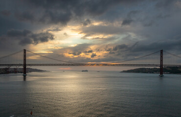 Panoramic Exposure done from a Cruise ship, while arriving at Lisbon at sunrise, of the 25th April Bridge and Tagus River, with Lisbon on the left bank and the Sanctuary of Christ the King, Portugal