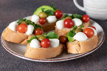 Bruschetta with tuna pate, avocado, mozzarella, olives and cherry tomatoes