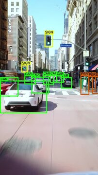 Autonomous or driverless car driving through a crowded street in Los Angeles. Computer vision with object detection system that creates boxes to recognize the different objects in the streets. AI.