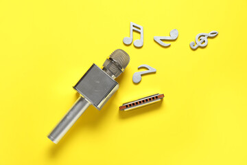 Composition with harmonica, microphone and music notes on yellow background