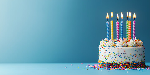  Birthday cake with festive candles on a blue background with space for text