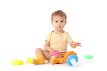 Cute baby girl in bodysuit playing with toy pyramid on white background