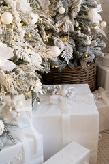 White elegant gifts under the Christmas tree. Christmas decor. Lights and balls on the Christmas tree
