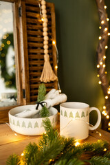 New Year's decor. Christmas composition on the fireplace. Cup and plate with Christmas trees