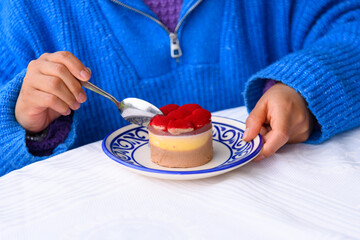 Woman in blue sweater eating tiramisu
