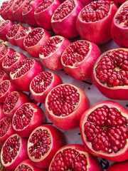 Rows of Ripe opened juicy pomegranates on the market