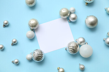 Composition with Christmas balls and blank card on blue background
