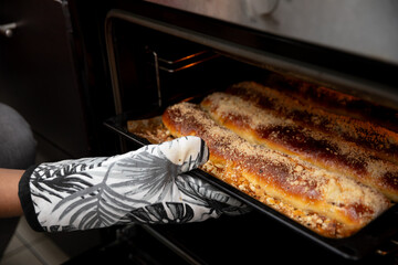 Carefully Baking a Freshly Cooked Dish Inside the Oven While Wearing a Protective Glove
