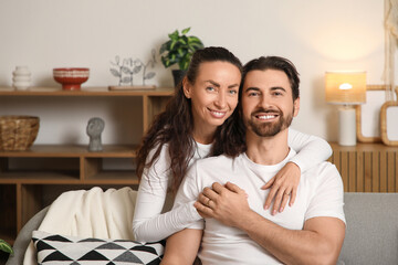 Fototapeta premium Happy wife hugging her husband at home