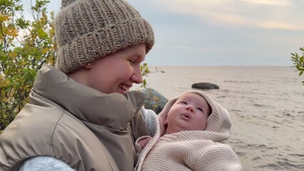 Obraz premium beautiful young woman mother with baby in her arms walking on the park