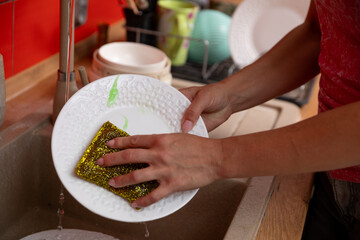 Washing the Dishes with a Soft Sponge in a Modernized Kitchen Environment at Home