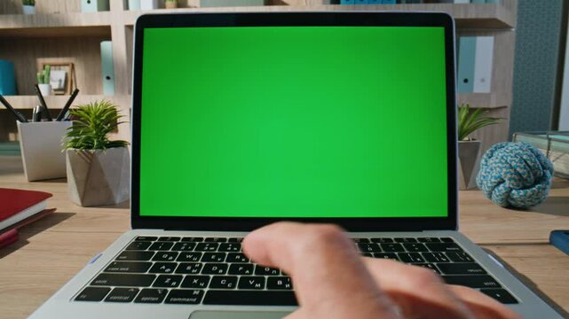 Hands tapping touchpad chroma key laptop at organized workplace closeup zoom out