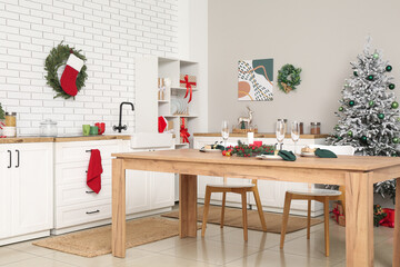 Interior of kitchen with counters, Christmas tree and dining table