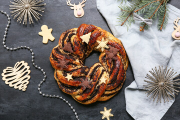 Composition with tasty Christmas pastry wreath, decorations and napkin on dark background