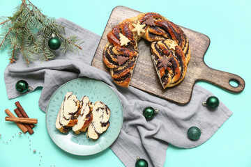 Composition with tasty Christmas pastry wreath, decorations and fir branch on color background