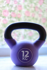 A close-up shot of a kettlebell resting on a window sill, ready for use.