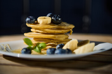 Stack of pancakes with blueberries and banana slices