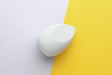 Egg makeup sponge. Blender for foundation on yellow gray background