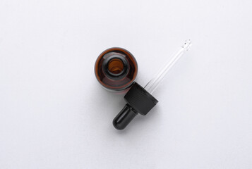 Glass Bottle of Facial Serum with pipette on white Background. Top view