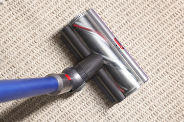 Cleaning carpet with cordless vacuum cleaner indoors, top view