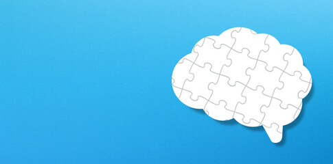 Brain shaped jigsaw puzzle on blue background