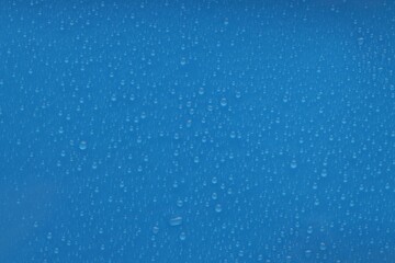 Water drops on blue background, top view