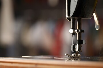 Sewing machine with thread on blurred background, macro view. Space for text