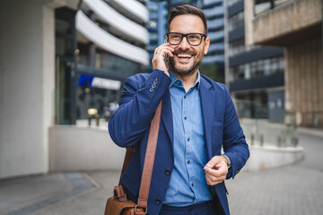 cheerful adult businessman talk on mobile phone while go to work