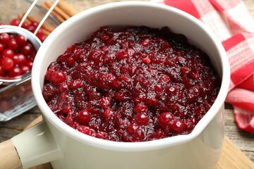 Tasty cranberry sauce in saucepan on table, closeup