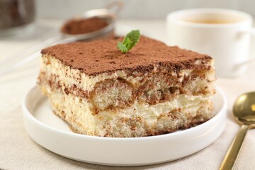 Delicious tiramisu with mint on light table, closeup