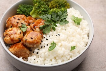 Tasty rice with broccoli, chicken and parsley on grey table, closeup