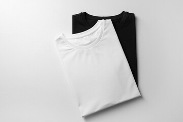 Different blank t-shirts on white background, top view. Mockup for design