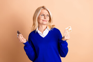 Confident senior businesswoman evaluating different medication options in a modern setting