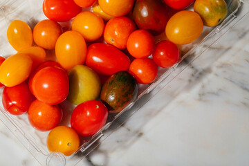 plastic box of mini heirloom tomatoes in different colors