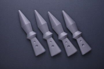Toy ninja throwing weapons on dark gray background