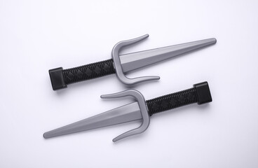 Toy plastic sai weapons on white background
