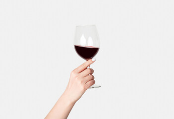 Young girl holding glass of tasty red wine on white background, close up