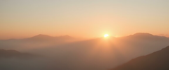 Obraz premium Epic Mountain Sunset: Golden Rays Breaking Through Misty Fog