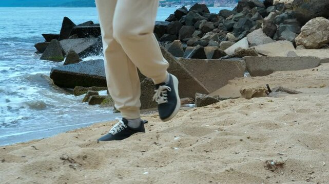 Man carefully walks along the beach, timing each step to evade the incoming waves. The serene environment offers a perfect blend of relaxation and mindfulness by the ocean