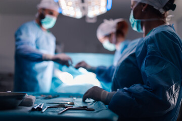 Surgeons perform a delicate operation under bright surgical lights.