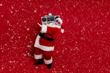 Photo of handsome funky santa claus wear red headwear hat dark glasses listening boom box dancing isolated red color background © deagreez