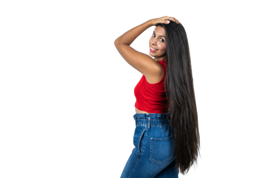 Latina Woman Shows Off Her Long Hair and Wears a Red Top and Blue Jeans. Smiling and Stylish