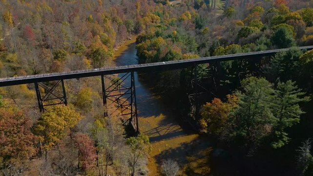 Aerial view of historic railroad bridge crossing a river valley, drone 4K