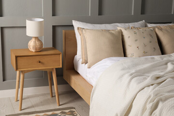 Bed with beautiful cushions in room. Interior design