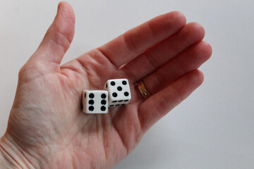 palm of hand with two dice of six and five isolated on white background. sixty-five 65 entertainment or retirement theme backdrop