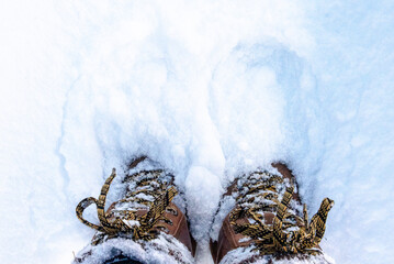 top down view of winter boots hidden in fresh snow
