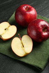 Whole and cut ripe red apples on grey textured table