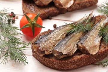Delicious sandwich with sprats, dill and tomato on white wooden table, closeup