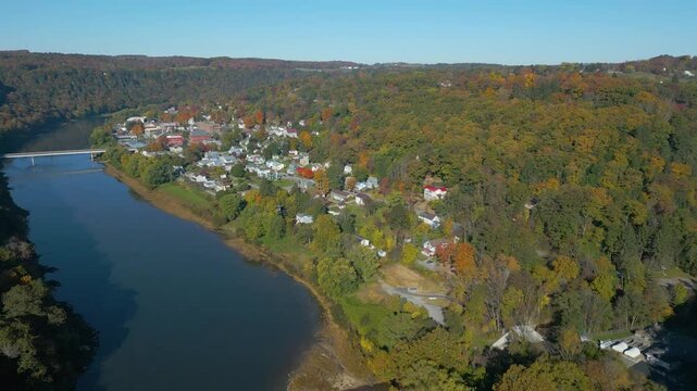 Aerial view of a small town on the mountainside with beautiful Fall foliage and fog, drone 4K