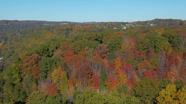 Aerial view of a small town on the mountainside with beautiful Fall foliage, drone 4K